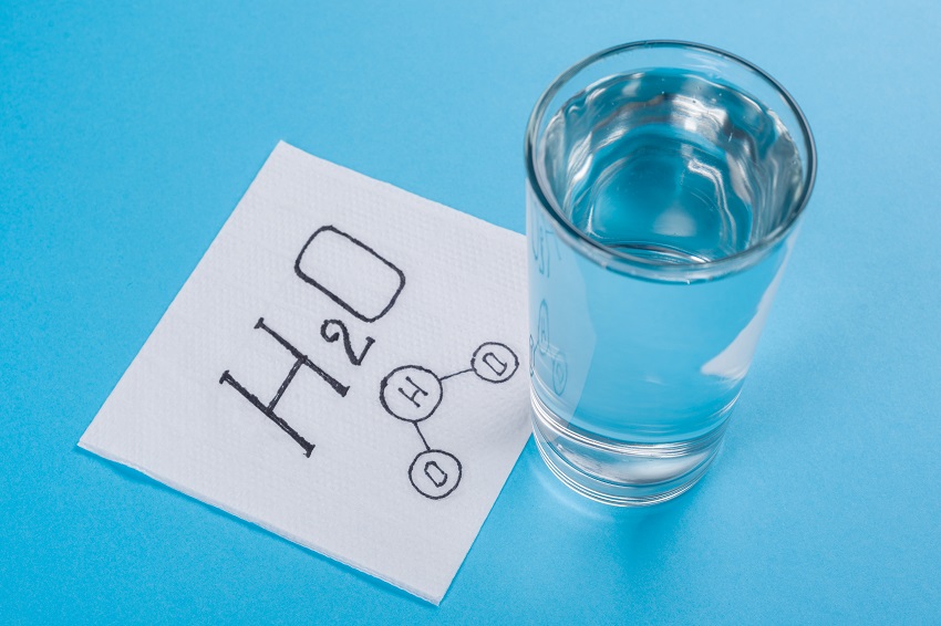 Glass with water, napkin with water formula, blue background.